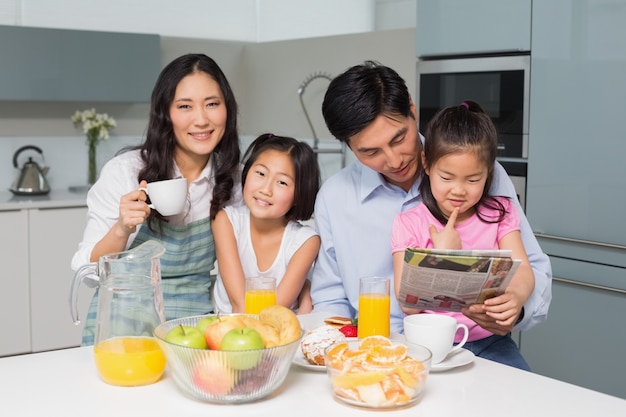 Famiglia di quattro persone godendo sana colazione in cucina