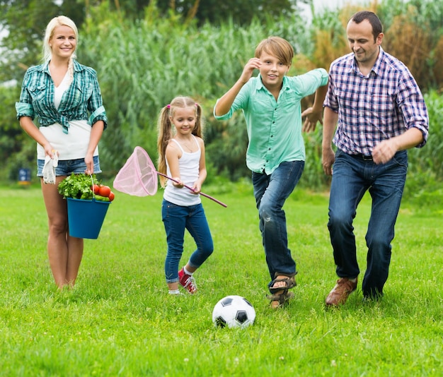 Famiglia di quattro persone che giocano a calcio e si divertono