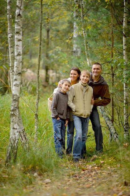 가을 숲에서 포즈를 취하는 4인 가족