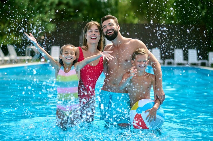 Photo family of four posing for the camera in the water