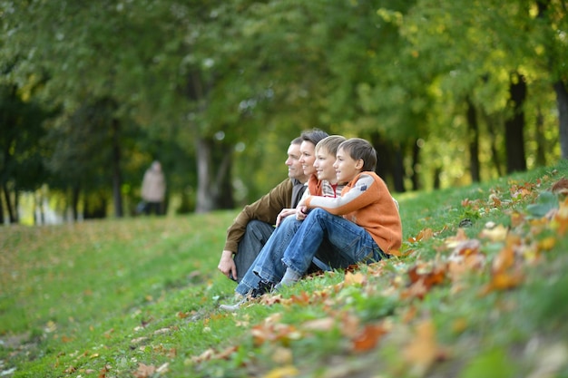 Family of four posing sitting on grass