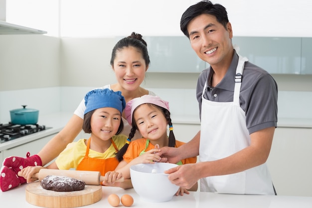 Family of four preparing cookies in kitchen