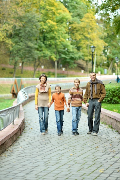 Family of four relaxing in autumn park