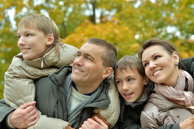 Foto famiglia di quattro persone che si rilassano nel parco in autunno