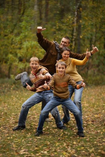 Photo family of four walking in autumn forest