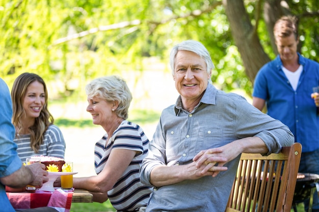 Photo family and friends having a picnic with barbecue