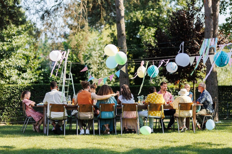Photo family and friends sitting at the party table during a summer garden party outdoors rear view of people sitting at the table