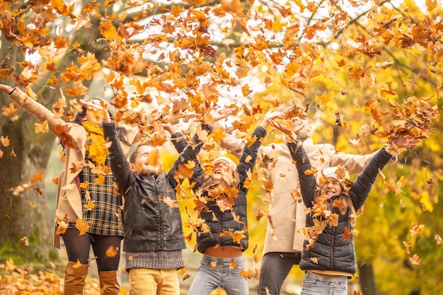 Family fun outdoors in the autumn by throwing fallen leaves up in the air.