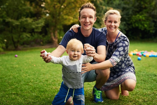 Family fun time in the backyard Shot of an adorable little boy and his parents playing in the backyard