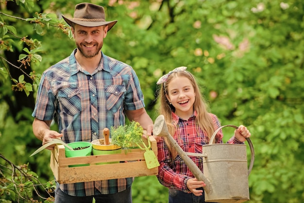 family garden maintain garden planting flowers family dad and daughter planting plants transplanting vegetables from nursery or gardening center plant your favorite veggies planting season