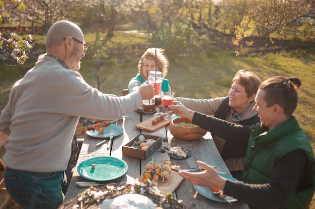 The family gathered at a festive table in the garden to celebrate easter