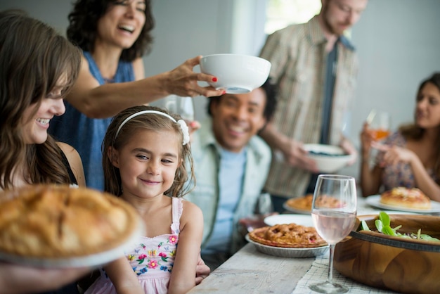 食事のために集まる家族大人と子供がテーブルの周りに