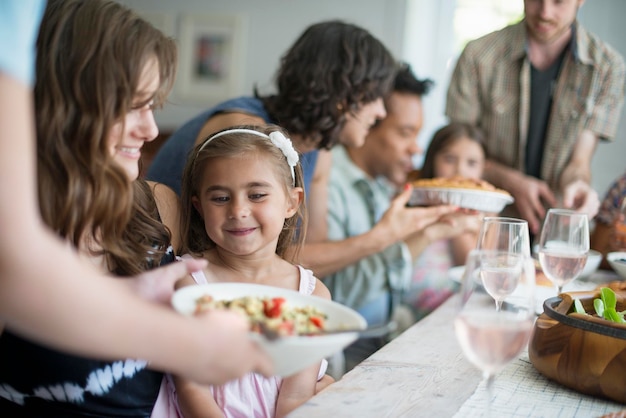 食事のために集まる家族大人と子供がテーブルの周りに