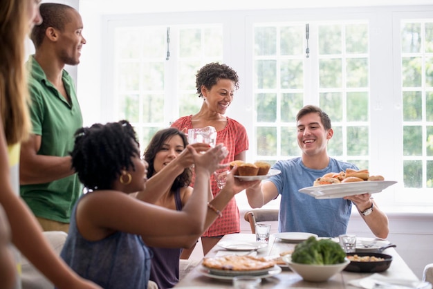 A family gathering men women and children around a dining table sharing a meal