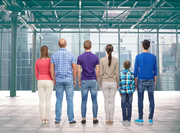 family, gender, generation and people concept - group of men, women and boy from back over terminal with window city view background