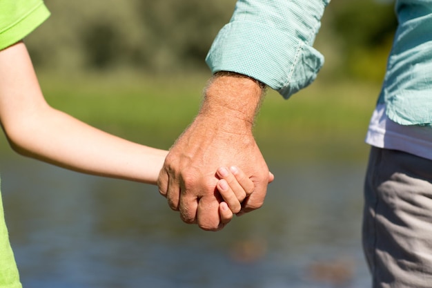 家族、世代、サポート、人々のコンセプト – 手を繋ぐ年配の男性と子供
