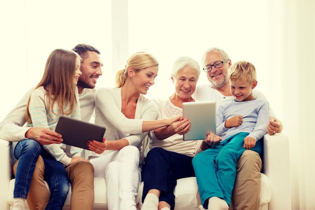 Photo family, generation, technology and people concept - smiling family with tablet pc computers at home