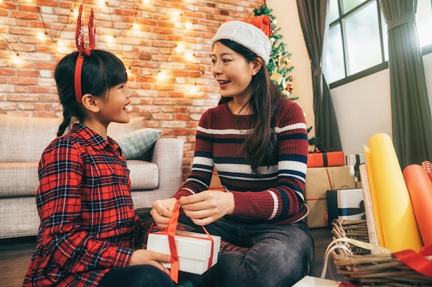 クリスマスイブの家族向けギフトラッピング.魅力的なサンタの女の子と美しい子供パック ギフト、一歩一歩。メリー クリスマスとハッピー ホリデー。オープン ギフト ボクシングデーのコンセプトです。