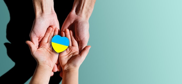 Family hands holding a heart in ucrainian colours Peace and no war concept