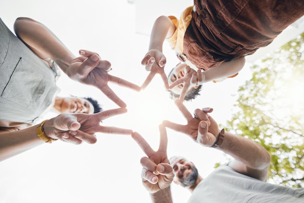 Foto mani della famiglia unite e dita a stella all'aperto ad angolo basso, felici e legati. padre, madre e figlio si stringono nell'amore, nella solidarietà e nel sostegno interrazziale nella cooperazione, nella connessione e nel successo