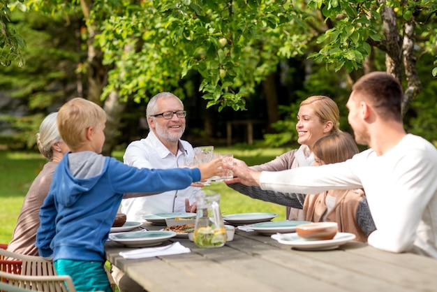 family, happiness, generation, home and people concept - happy family having holiday dinner outdoors