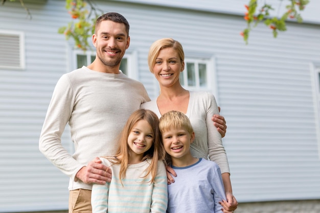 family, happiness, generation, home and people concept - happy family standing in front of house outdoors