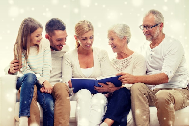 Photo family, happiness, generation and people concept - happy family with book or photo album sitting on couch at home