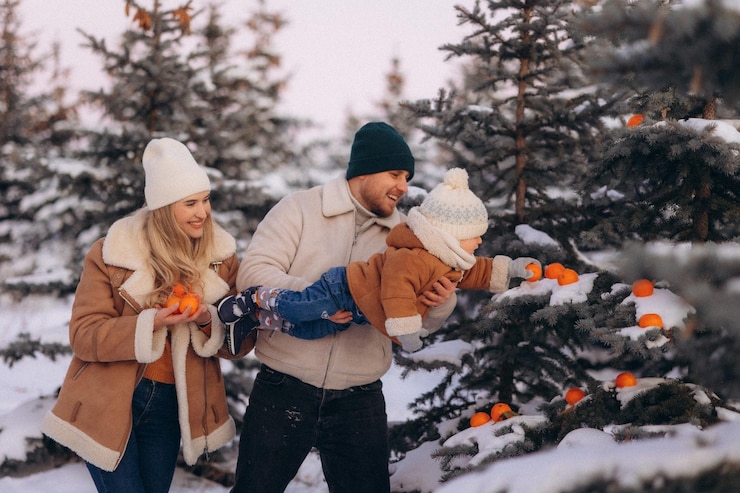 Photo the family has fun in the winter in the park with fir trees
