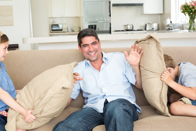 Family having cushion fight on sofa