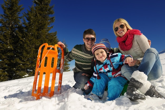 Photo family having fun on fresh snow at winter vacation