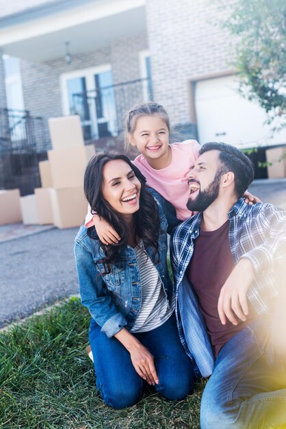 family having fun together outdoors while sitting on grass