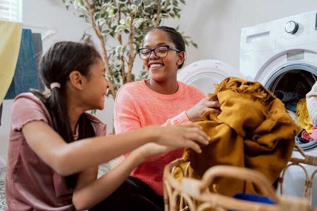 Family help with household chores putting laundry in the\
washing machine colorful dirty things taken