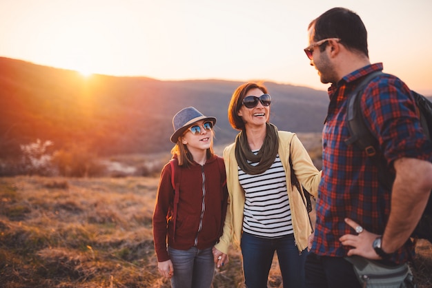 Family hiking and having fun on mountain during sunset