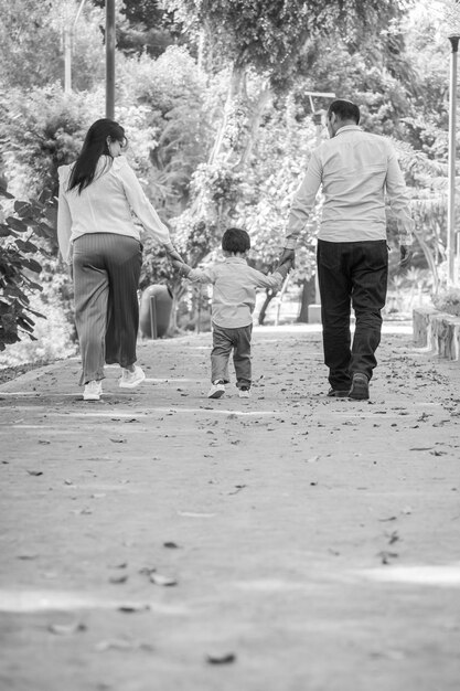 Family holding hands while they walk on a park in the daytime in Peru Lima