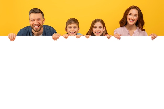 Photo family holding a white blank banner on yellow background