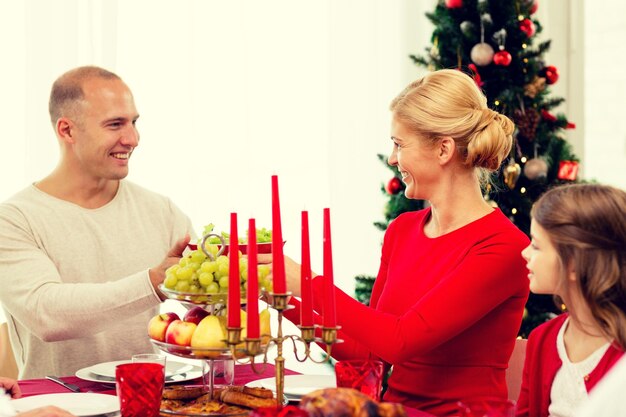 Foto concetto di famiglia, vacanze, generazione, natale e persone - famiglia sorridente che cena a casa