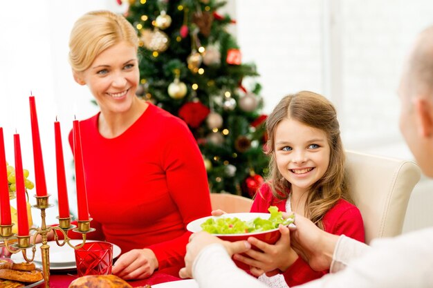 家族、休日、世代、クリスマス、人々の概念-家で夕食をとっている笑顔の家族