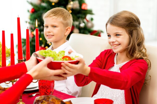 家族、休日、世代、クリスマス、人々の概念-家で夕食をとっている笑顔の家族