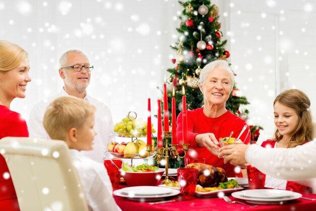 家族、休日、世代、クリスマス、人々の概念-家で夕食をとっている笑顔の家族