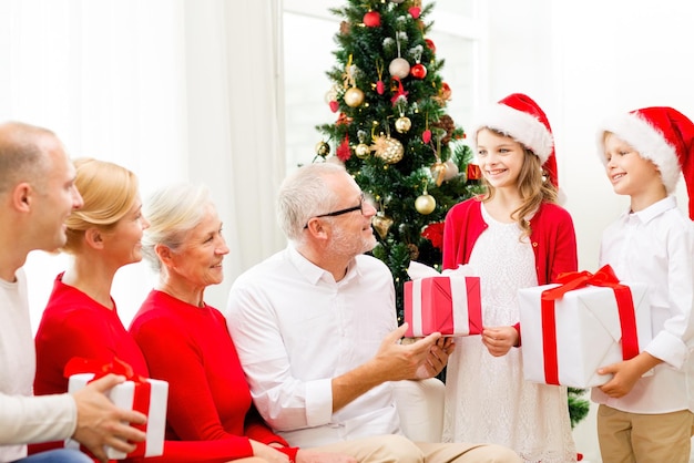 family, holidays, generation, christmas and people concept - smiling family with gift boxes at home