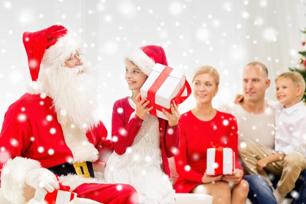 家族、休日、世代、クリスマス、人々のコンセプト-自宅でサンタクロースとギフトボックスを持つ笑顔の家族