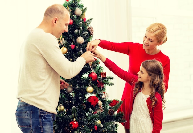 家族、休日、世代、人々の概念-家でクリスマスツリーを飾る笑顔の家族