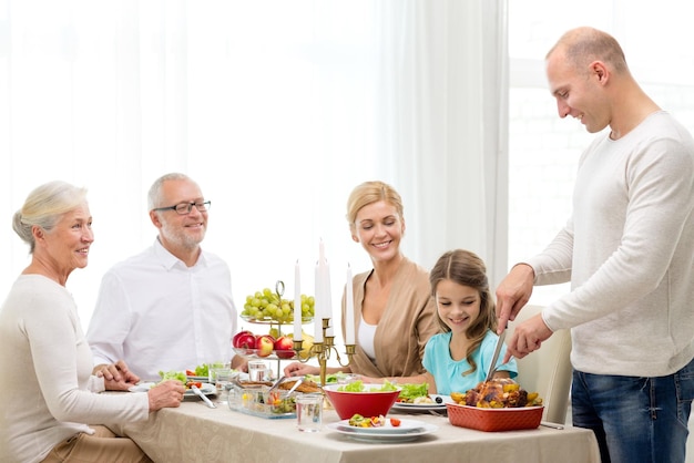 family, holidays, generation and people concept - smiling family having dinner at home