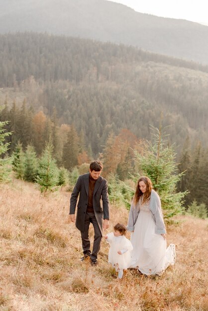 Family hugging and playing in mountains