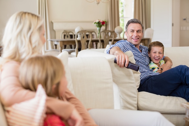 Family interacting with each other while watching tv in living room