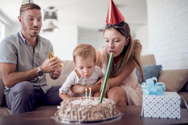 Family is blowing out candle on a birthday cake