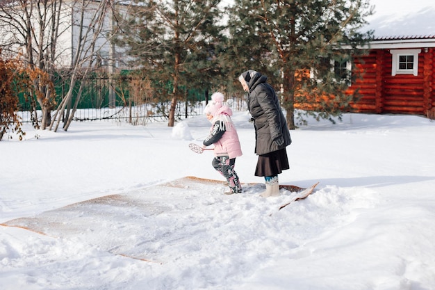 Photo family is cleaning carpet in backyard caucasian woman and child traditionally clean carpet with fres...