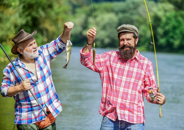 Photo family is the link to our past male friendship family bonding summer weekend mature men fisher hobby and sport activity trout bait two fisherman with fishing rods father and son fishing