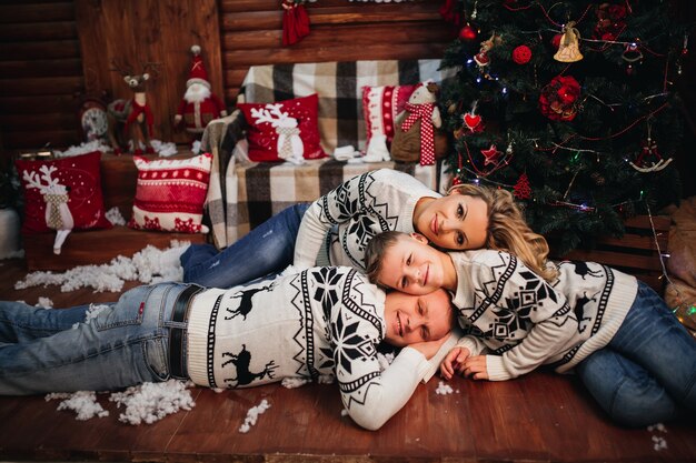 family is lying on the floor in identical sweaters