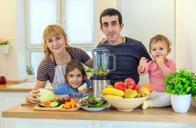 The family is making smoothies in the kitchen. Selective focus.